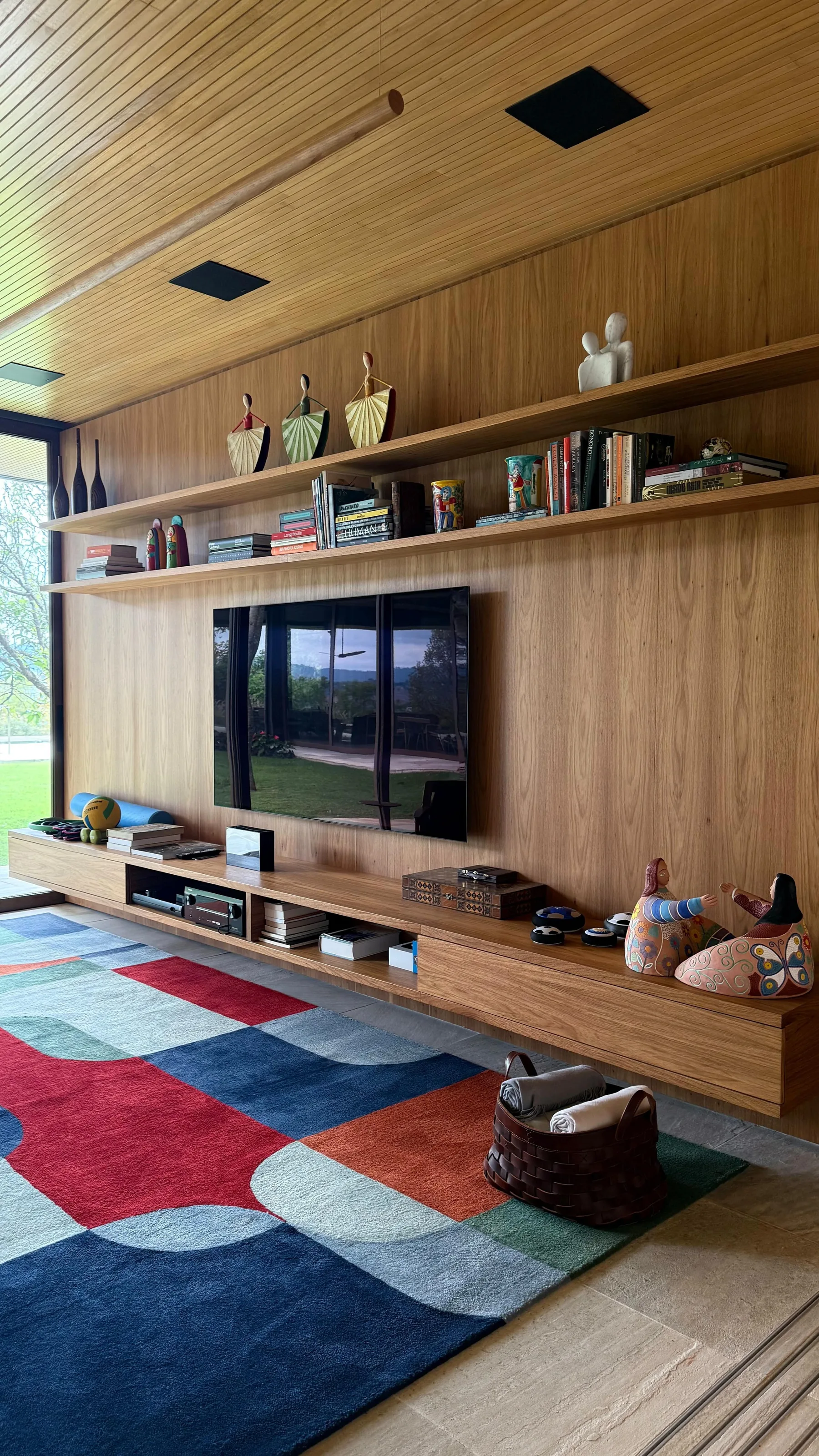 Sala de TV com painel e forro de madeira